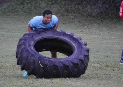 black man flipping tractor tire
